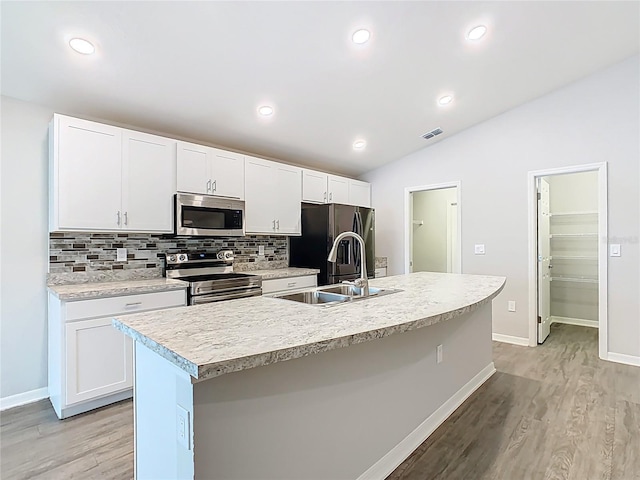 kitchen with visible vents, a sink, stainless steel appliances, light countertops, and tasteful backsplash