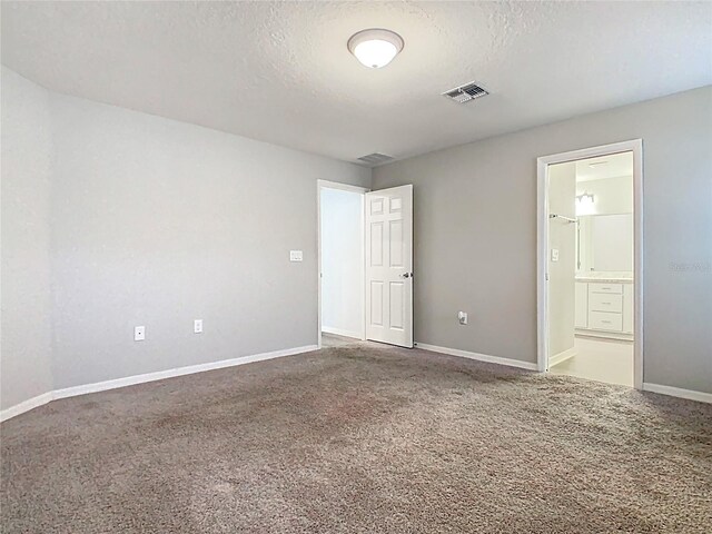 unfurnished room featuring baseboards, visible vents, a textured ceiling, and carpet