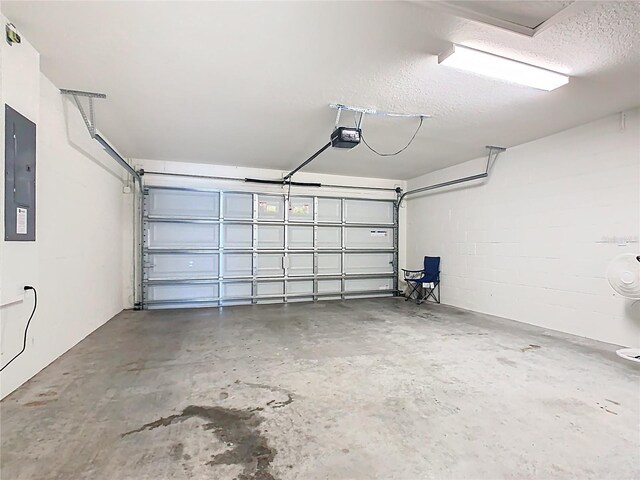 garage featuring electric panel, a garage door opener, and concrete block wall