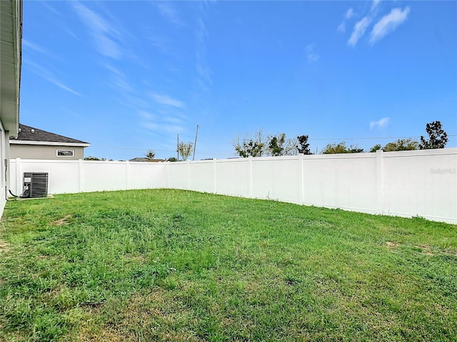 view of yard with central air condition unit and fence