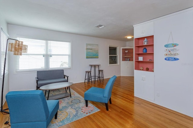 living area featuring visible vents and light wood-style flooring