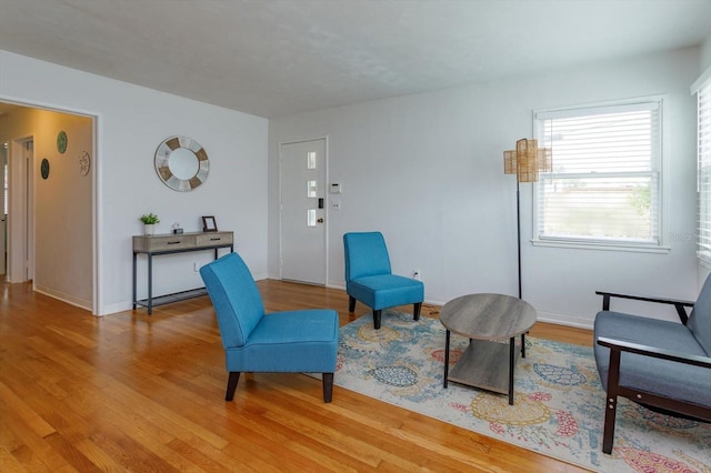 living area with light wood-type flooring and baseboards