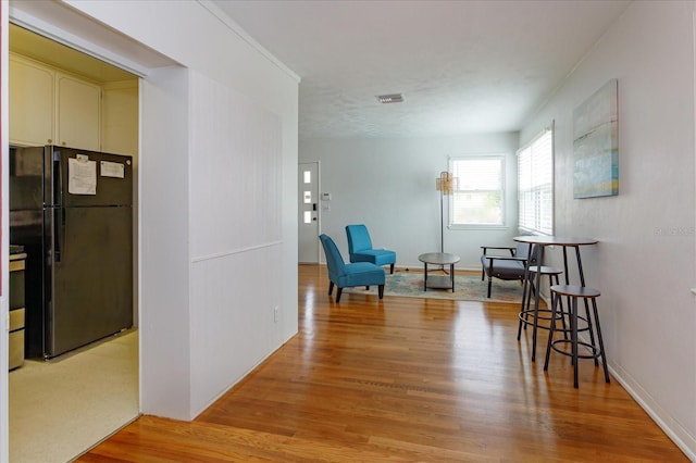 interior space with light wood-style floors, visible vents, and baseboards