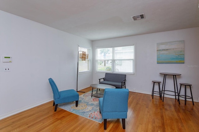 sitting room with visible vents, baseboards, and wood finished floors