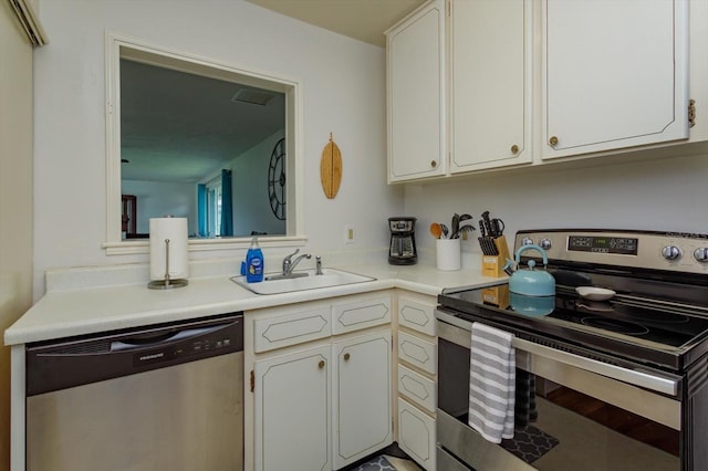 kitchen featuring white cabinets, stainless steel appliances, light countertops, and a sink