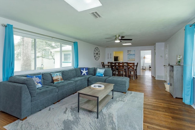 living room with visible vents, a ceiling fan, and wood finished floors