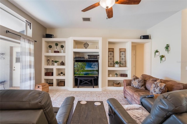 living room with visible vents, built in shelves, and ceiling fan