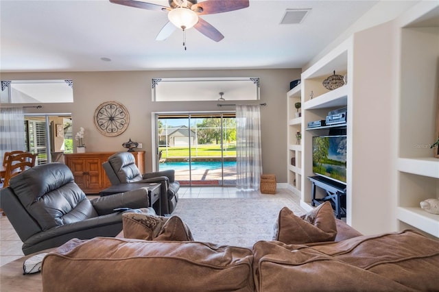 tiled living area with visible vents, built in shelves, and ceiling fan