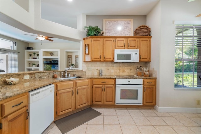 kitchen with white appliances, light stone countertops, tasteful backsplash, and a sink