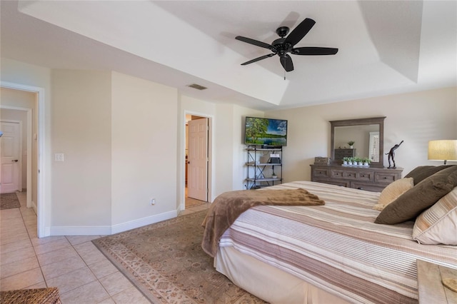 bedroom featuring visible vents, baseboards, light tile patterned floors, a raised ceiling, and ceiling fan