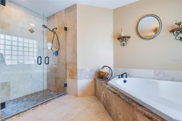 bathroom with a bath, tile patterned flooring, and a shower stall