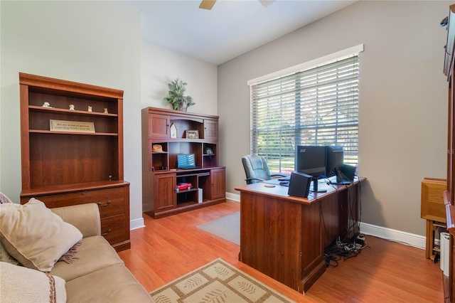 office space featuring light wood finished floors, a ceiling fan, and baseboards