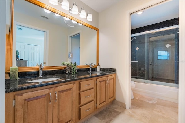 bathroom with double vanity, visible vents, toilet, and a sink