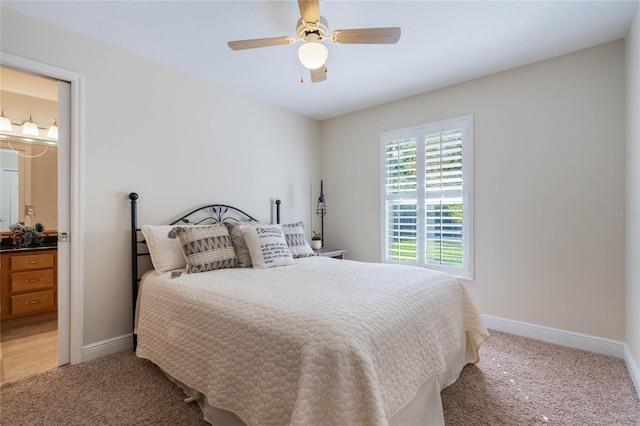 bedroom with ceiling fan, baseboards, light carpet, and connected bathroom