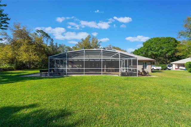 back of property with a lanai, a lawn, and a patio area