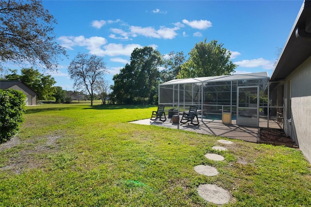 view of yard featuring glass enclosure, a swimming pool, and a patio area