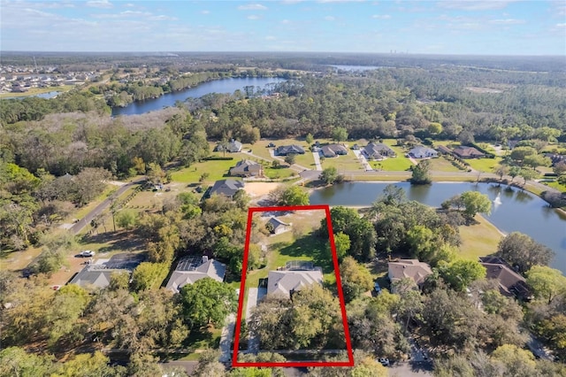 aerial view with a wooded view and a water view