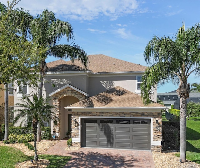 view of front of home with stucco siding, decorative driveway, stone siding, an attached garage, and a shingled roof