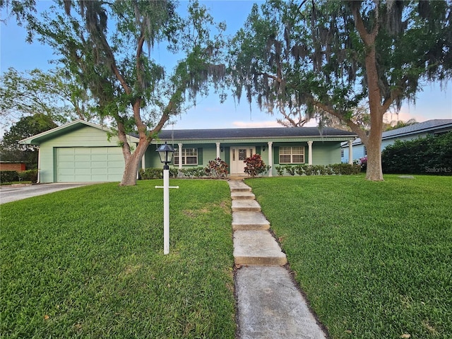 single story home featuring driveway, an attached garage, and a front lawn