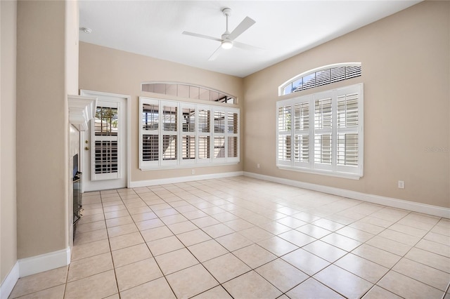 spare room featuring ceiling fan, baseboards, and light tile patterned floors