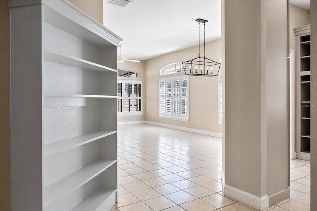 unfurnished dining area with a chandelier, light tile patterned flooring, visible vents, and baseboards