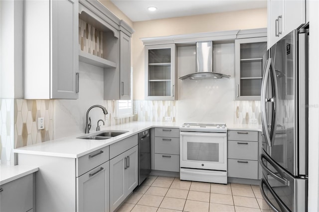 kitchen with wall chimney exhaust hood, gray cabinets, stainless steel appliances, a sink, and light tile patterned flooring