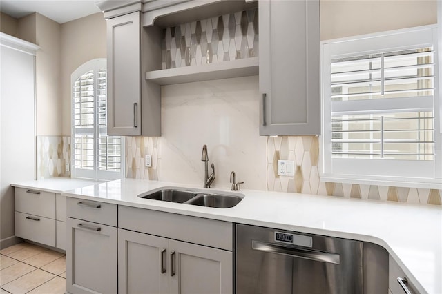 kitchen with decorative backsplash, dishwasher, light countertops, open shelves, and a sink