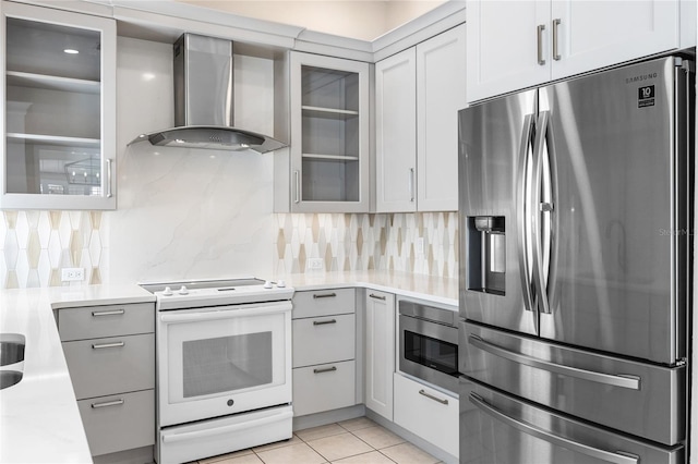 kitchen featuring wall chimney exhaust hood, appliances with stainless steel finishes, light tile patterned flooring, and tasteful backsplash