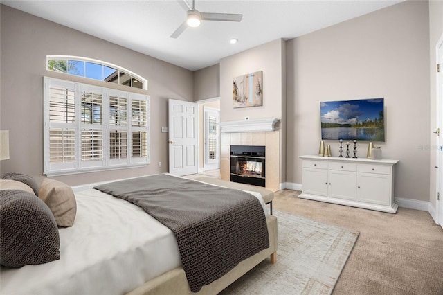 bedroom featuring recessed lighting, light carpet, ceiling fan, a tile fireplace, and baseboards