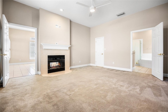 unfurnished living room featuring a ceiling fan, a tile fireplace, carpet flooring, and visible vents