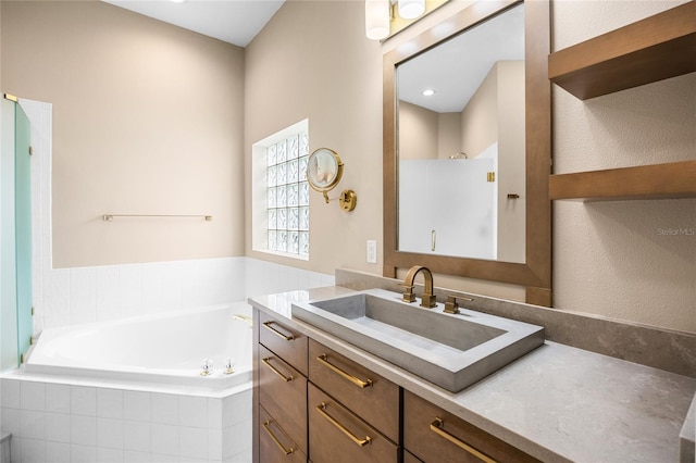 bathroom with a garden tub, a shower, and vanity