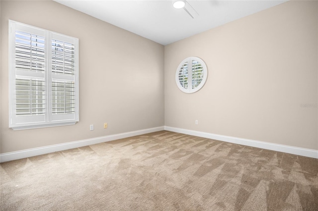 carpeted empty room with baseboards