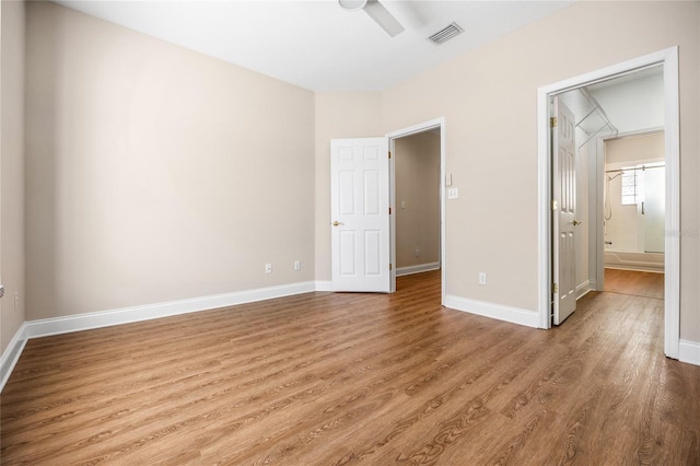 unfurnished bedroom with visible vents, light wood-style floors, connected bathroom, ceiling fan, and baseboards