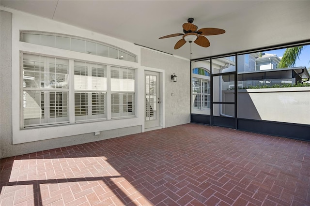 unfurnished sunroom with a ceiling fan