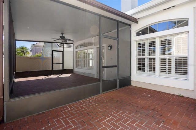 view of patio / terrace featuring a sunroom and a ceiling fan