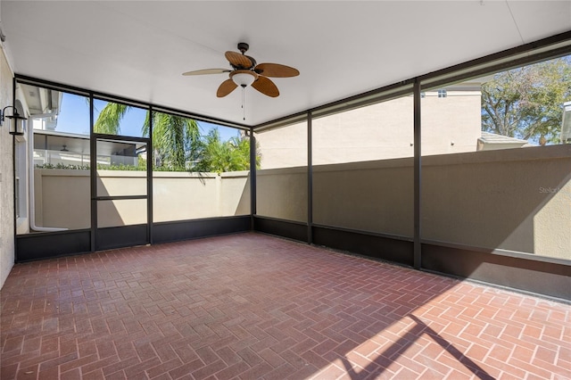 unfurnished sunroom with ceiling fan