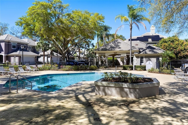 pool with a patio area and fence