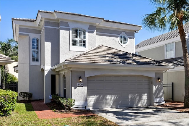 view of front of home featuring driveway, a tiled roof, and stucco siding