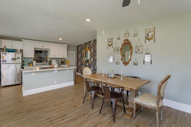 dining room featuring baseboards, recessed lighting, light wood-type flooring, and ceiling fan