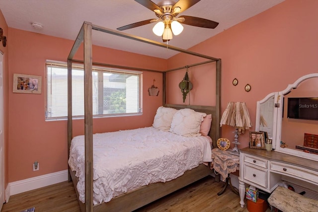 bedroom featuring ceiling fan, baseboards, and wood finished floors