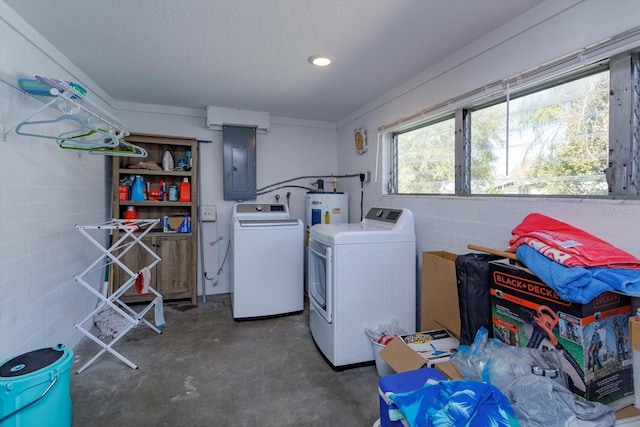 laundry area featuring washer and dryer, electric panel, concrete block wall, and electric water heater