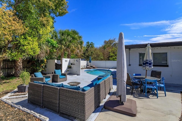 view of swimming pool with a patio, a fenced in pool, outdoor dining area, a fenced backyard, and an outdoor living space with a fire pit