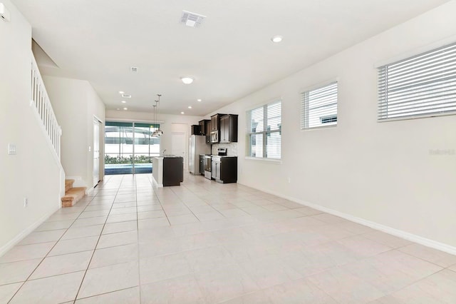 unfurnished living room with light tile patterned floors, visible vents, stairway, and recessed lighting