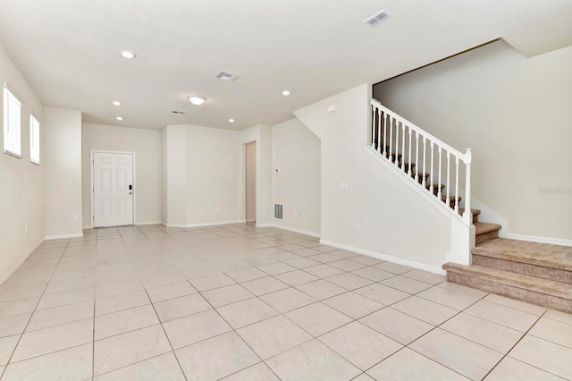 empty room featuring stairs, light tile patterned flooring, visible vents, and recessed lighting