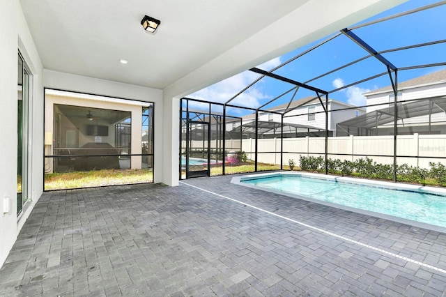 view of swimming pool featuring glass enclosure, a fenced in pool, and a patio