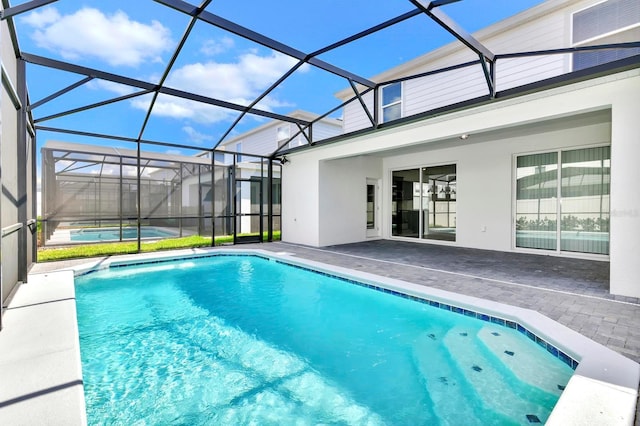 outdoor pool with a patio and glass enclosure