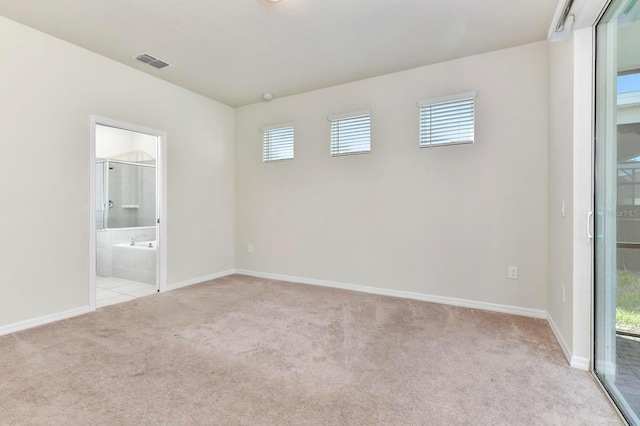 carpeted spare room featuring baseboards, visible vents, and a wealth of natural light