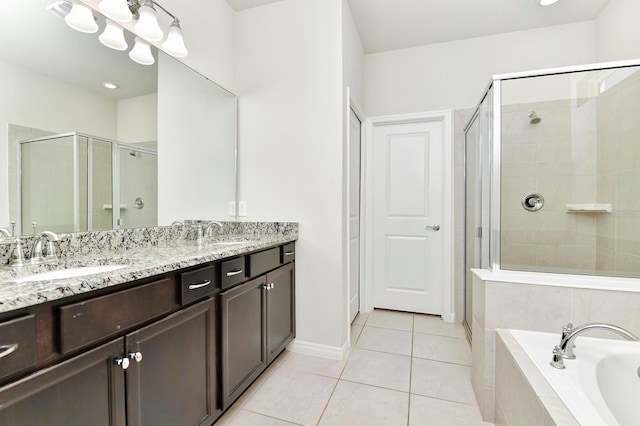 bathroom featuring a sink, a shower stall, a garden tub, and tile patterned floors