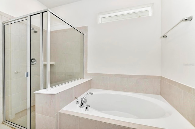 bathroom featuring a stall shower and a bath