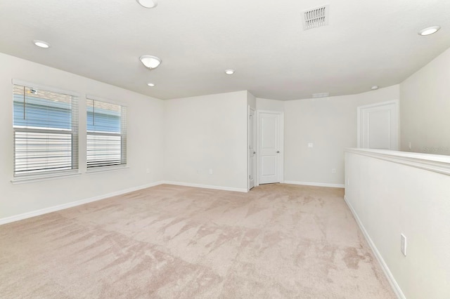 spare room with light carpet, recessed lighting, visible vents, and baseboards